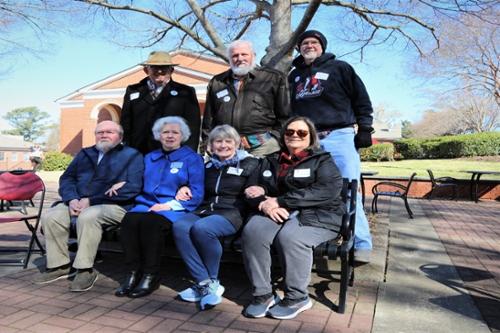Group of alumni pose at Caswell Plaza